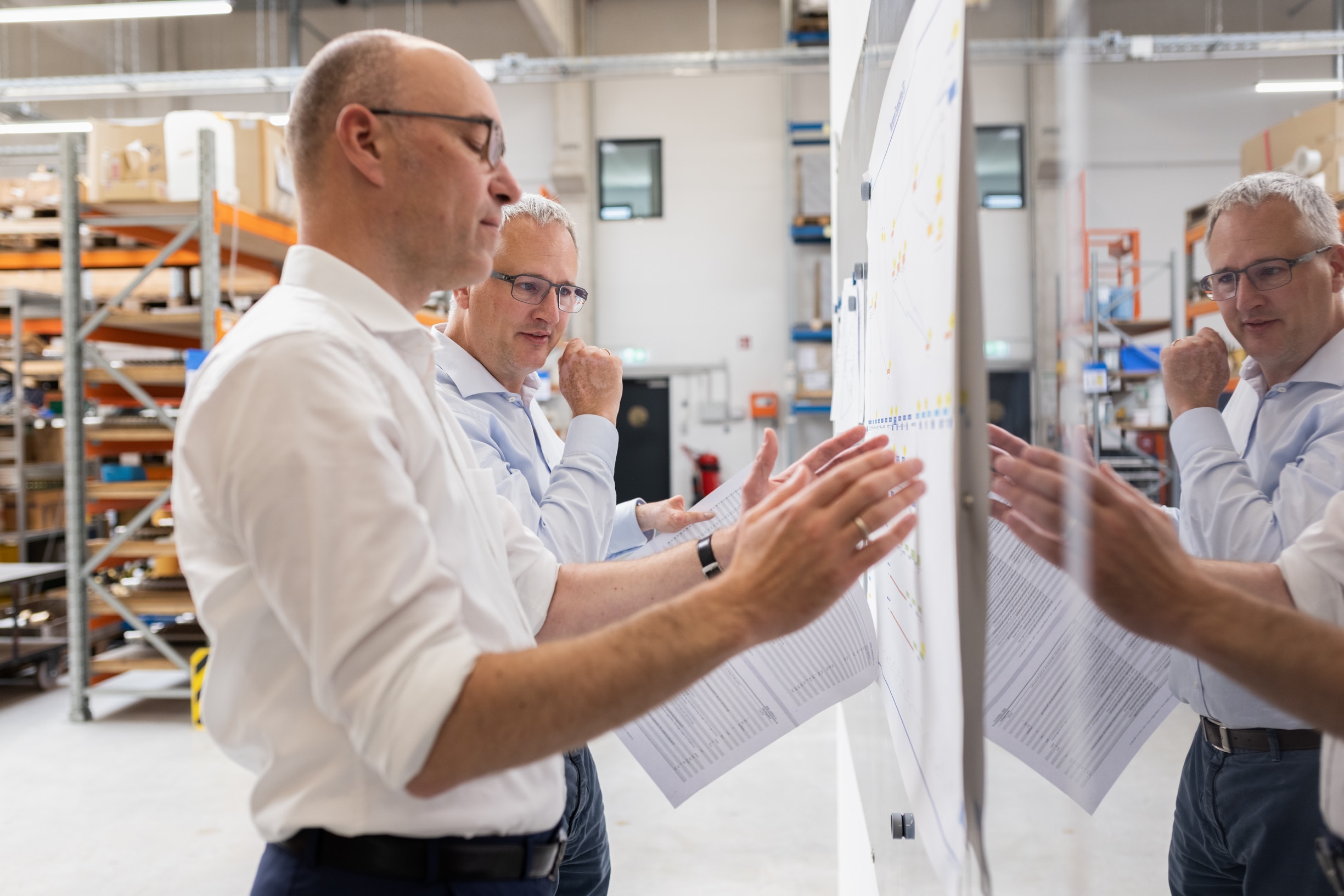 Zwei pareto-Partner analysieren einen Prozessplan an der Shopfloor-Tafel im Lager